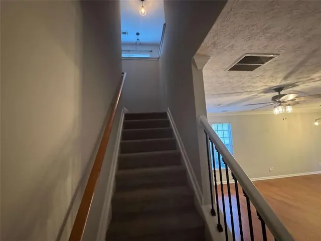 a view of staircase with wooden floor and white walls