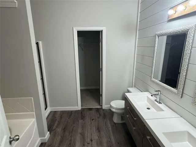 a bathroom with a sink a toilet and mirror