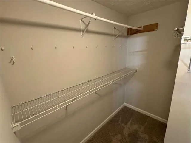 an empty room with a chandelier fan and a window