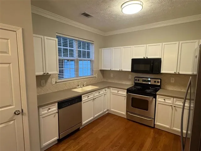 a kitchen with a sink stove and microwave