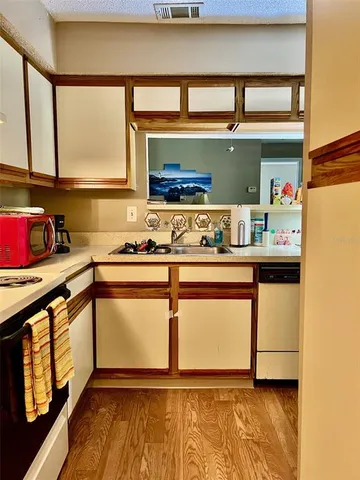 a living room with dining room and couches with wooden floor
