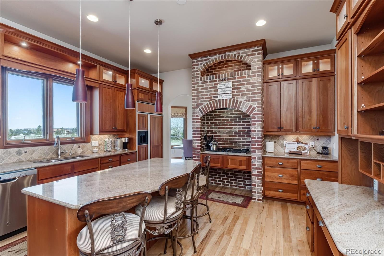 12080 Summit Ridge Road Parker, CO 80138 - Photo 15 of 39 a dining hall with stainless steel appliances granite countertop a stove and a wooden cabinets