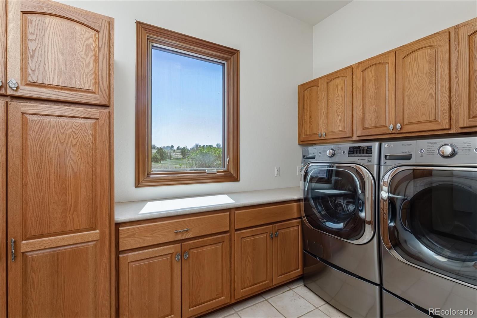 12080 Summit Ridge Road Parker, CO 80138 - Photo 19 of 39 a utility room with stainless steel appliances granite countertop a refrigerator and a sink
