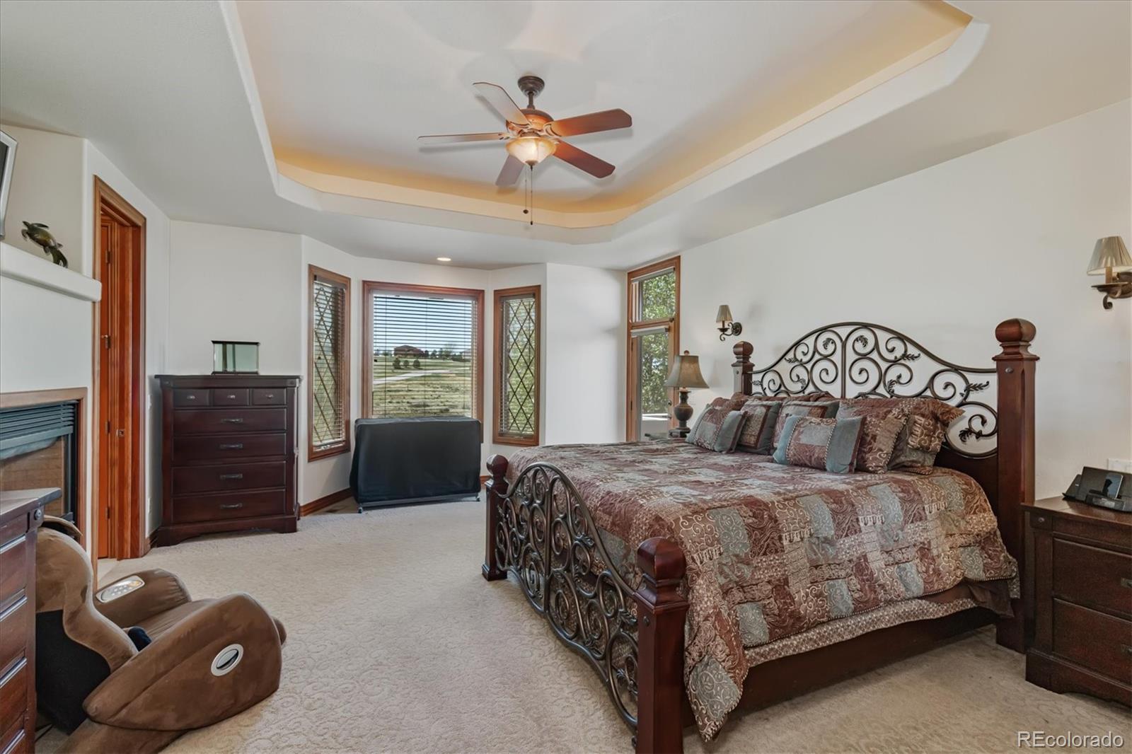12080 Summit Ridge Road Parker, CO 80138 - Photo 21 of 39 a bedroom with a bed and a chandelier