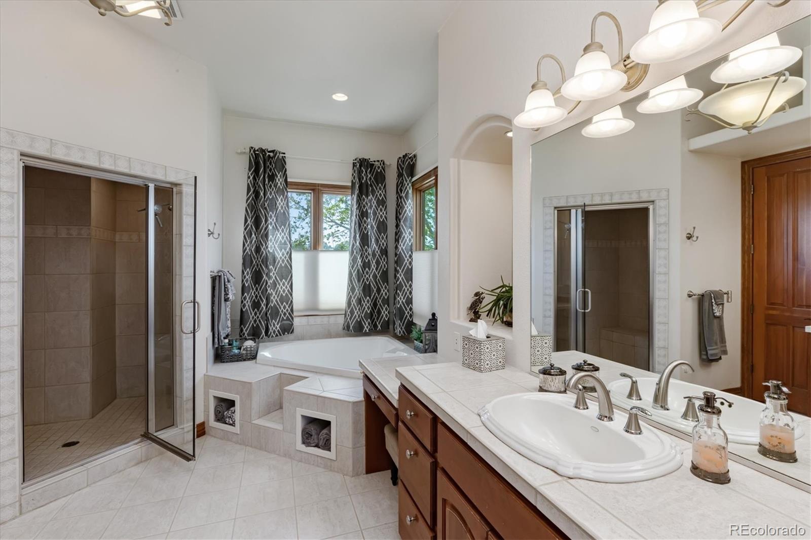 12080 Summit Ridge Road Parker, CO 80138 - Photo 23 of 39 a spacious bathroom with a granite countertop sink a toilet and a mirror