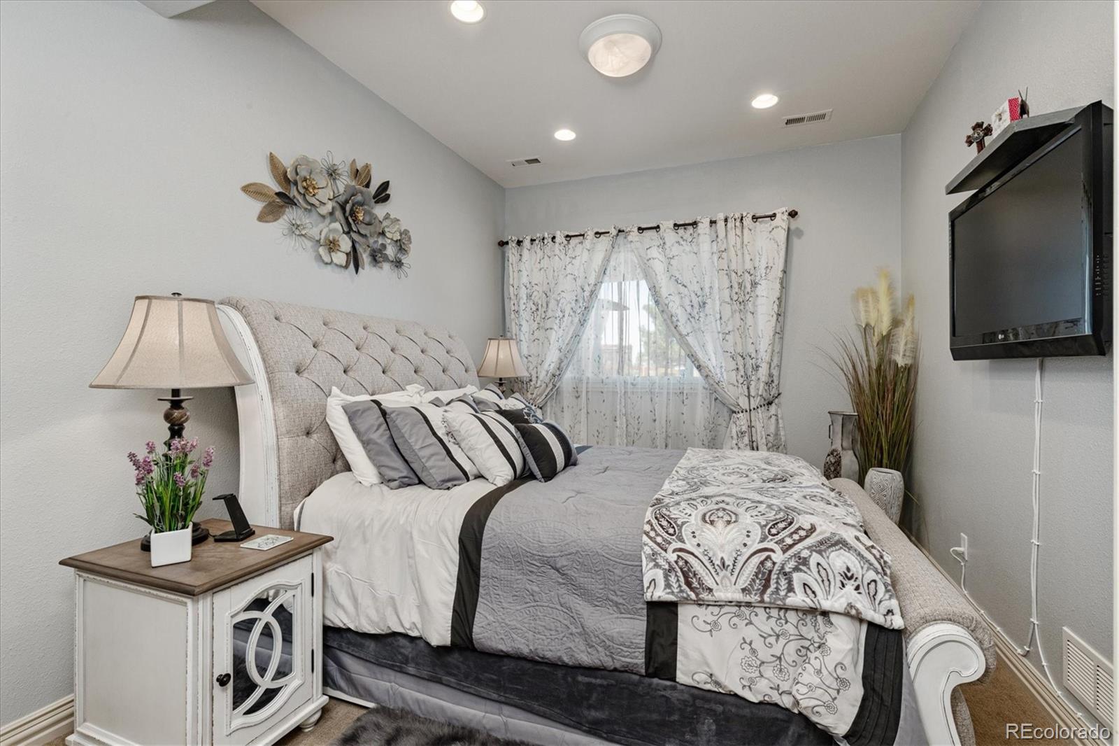 12080 Summit Ridge Road Parker, CO 80138 - Photo 30 of 39 a bedroom with a bed and a flat screen tv