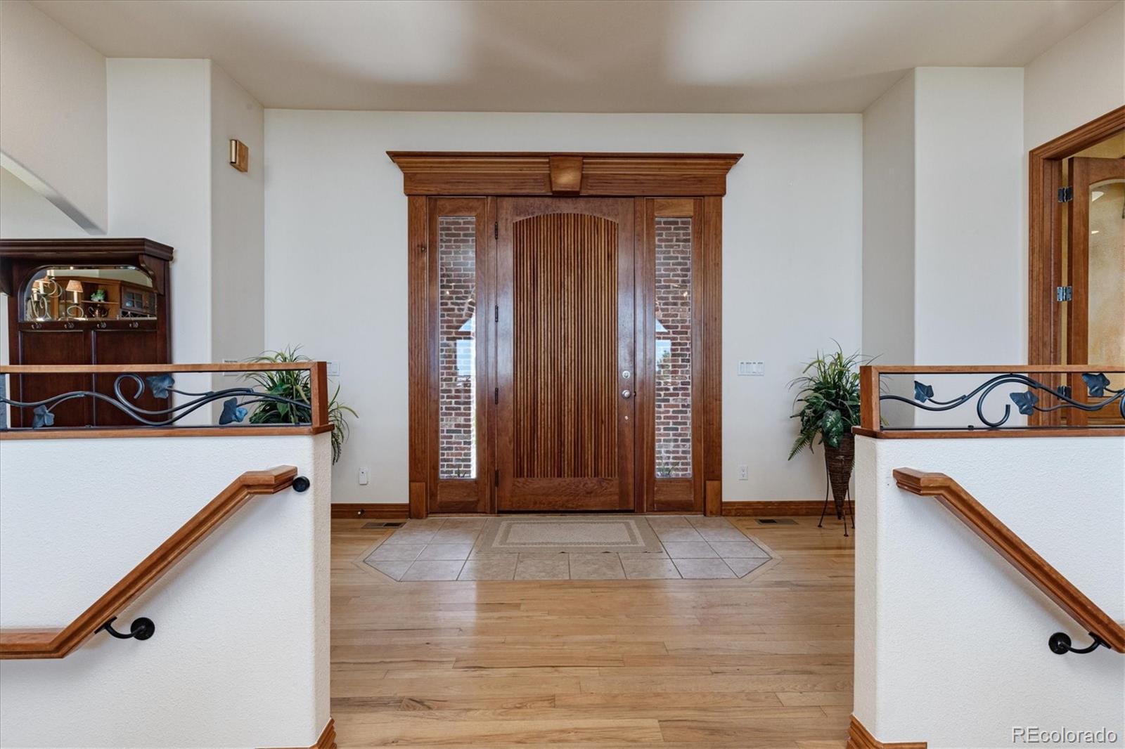 12080 Summit Ridge Road Parker, CO 80138 - Photo 7 of 39 a view of a hallway with wooden floor and a potted plant