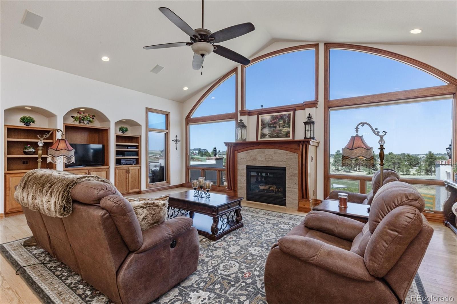 12080 Summit Ridge Road Parker, CO 80138 - Photo 8 of 39 a living room with furniture ceiling fan and a fireplace