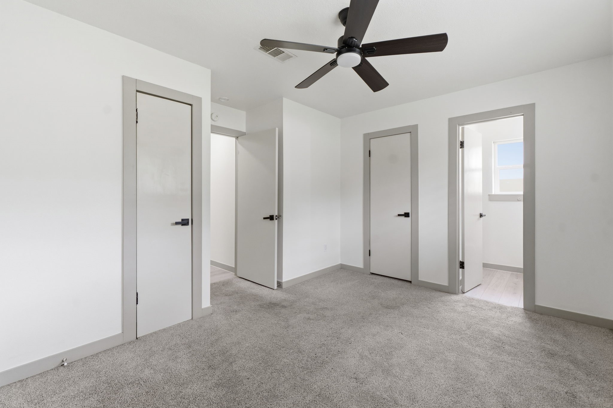 14850 Coaltown Road Willis, TX 77378 - Photo 22 of 41 Spacious primary suite with ceiling fan, soft carpeting, large window, and private en-suite bathroom access.