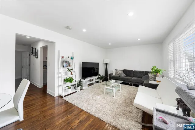 a living room with furniture wooden floor and a flat screen tv
