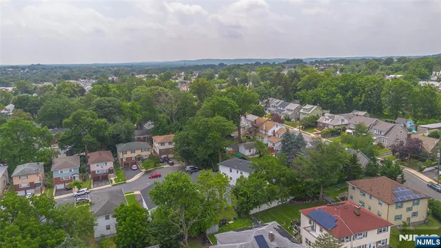 an aerial view of residential houses with outdoor space and trees