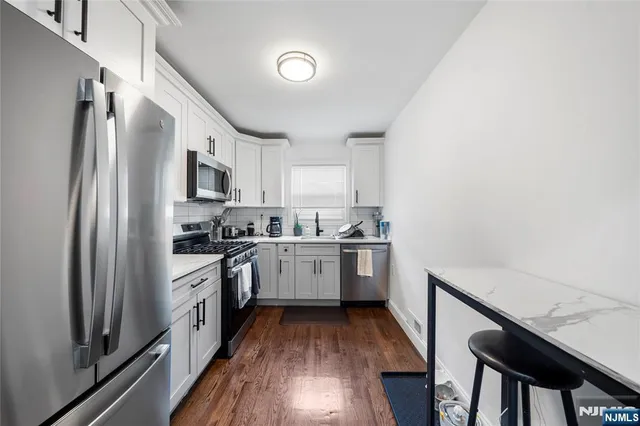 a kitchen with a sink stainless steel appliances cabinets and a counter top space