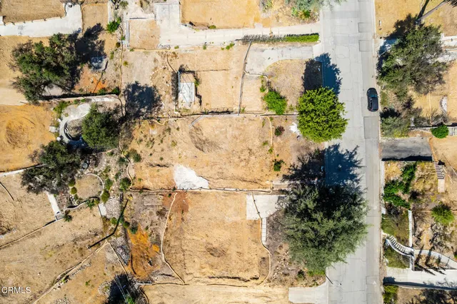 a view of a yard with wooden fence