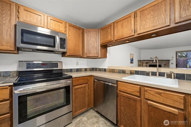 a kitchen with stainless steel appliances granite countertop a stove microwave and sink