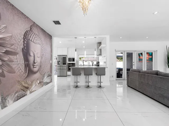 a large white kitchen with stainless steel appliances kitchen island granite countertop a large counter top space and cabinets