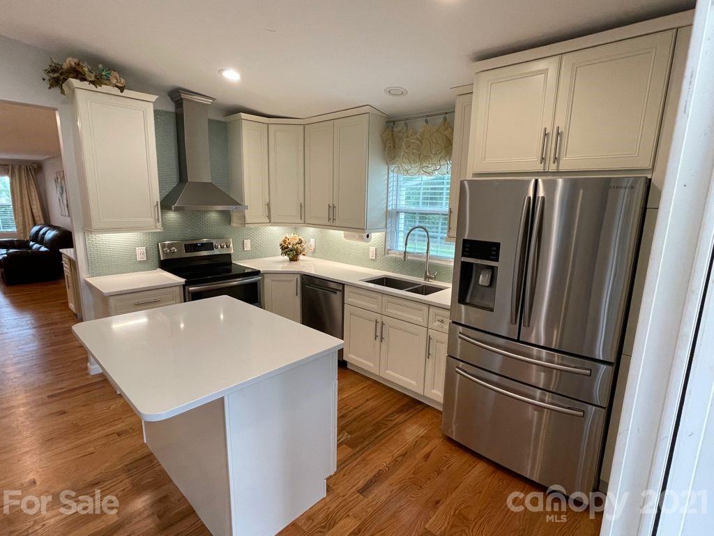 1803 Sim Williams Road Monroe, NC 28112 - Photo 7 of 12 a kitchen with a refrigerator a sink dishwasher and a stove with wooden floor