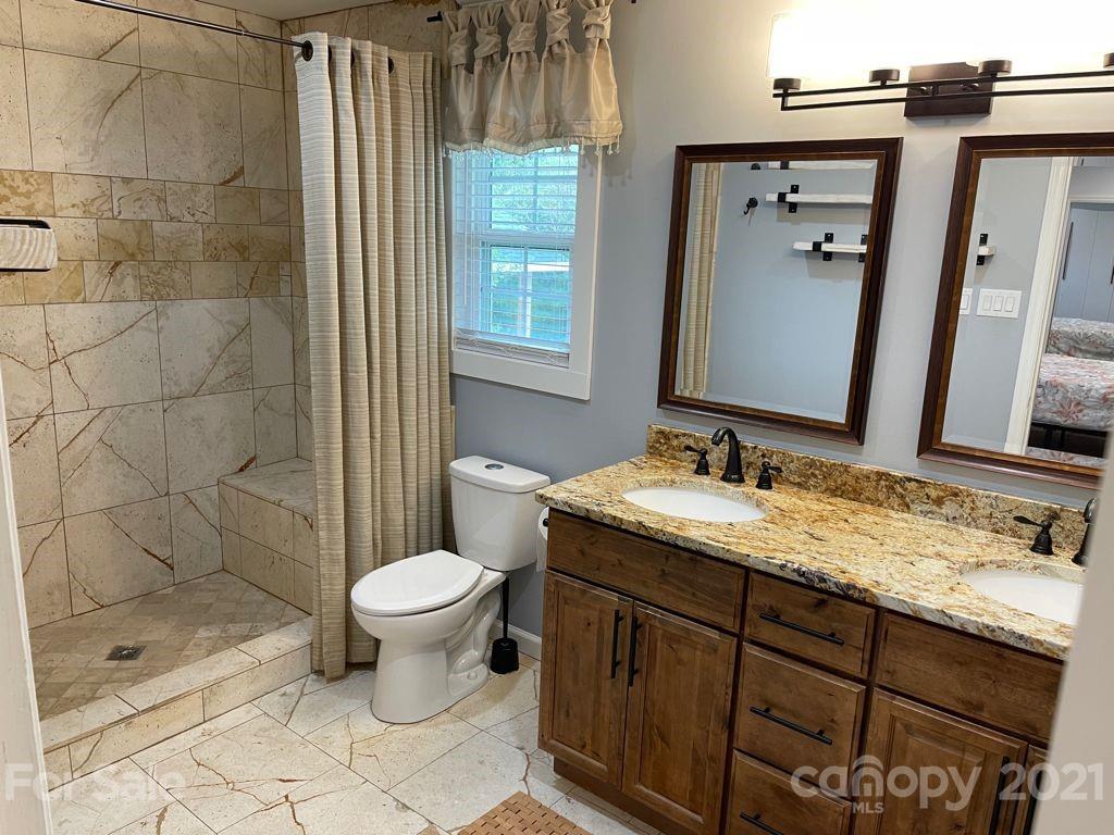 1803 Sim Williams Road Monroe, NC 28112 - Photo 9 of 12 a bathroom with a granite countertop sink toilet and shower