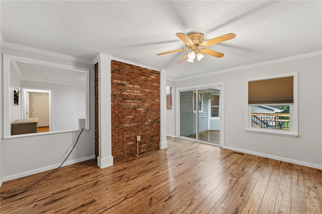 1014 East Queen Street Pendleton, SC 29670 - Photo 23 of 43 Rich hardwood floors complement a classic brick accent wall in this inviting living area.