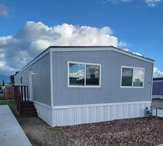 a view of a house with backyard and wooden fence