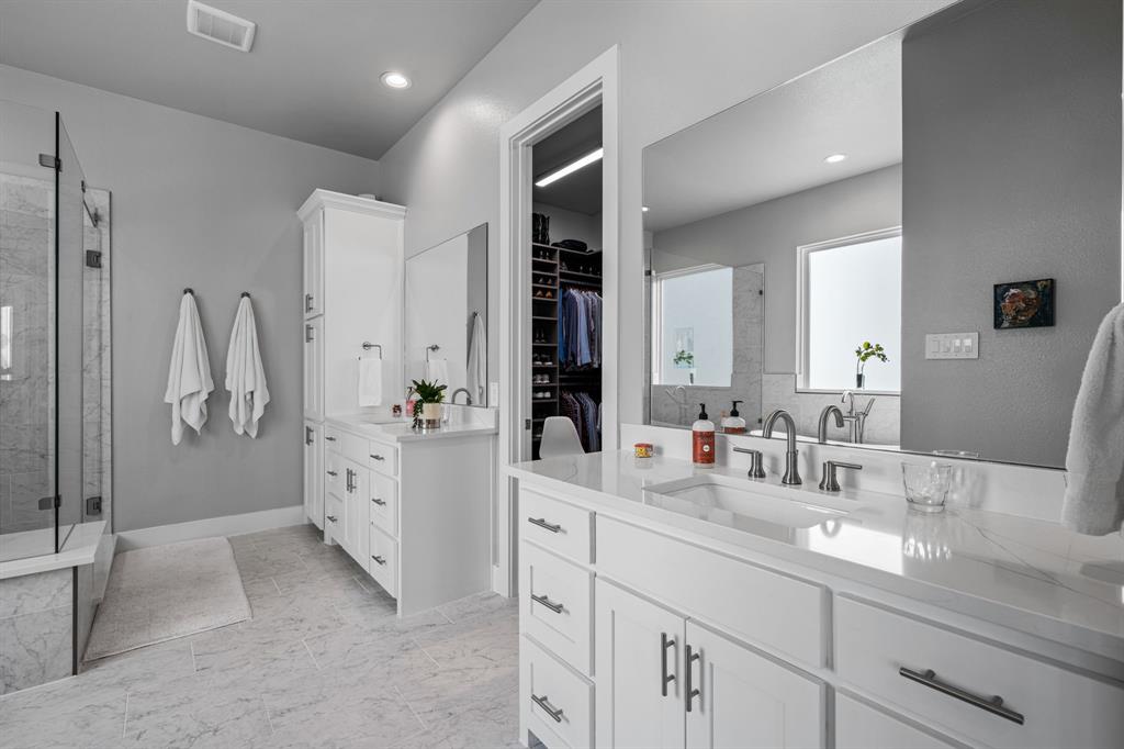 4138 Entrada Way Dallas, TX 75219 - Photo 19 of 40 a spacious bathroom with a double vanity sink a mirror and shower
