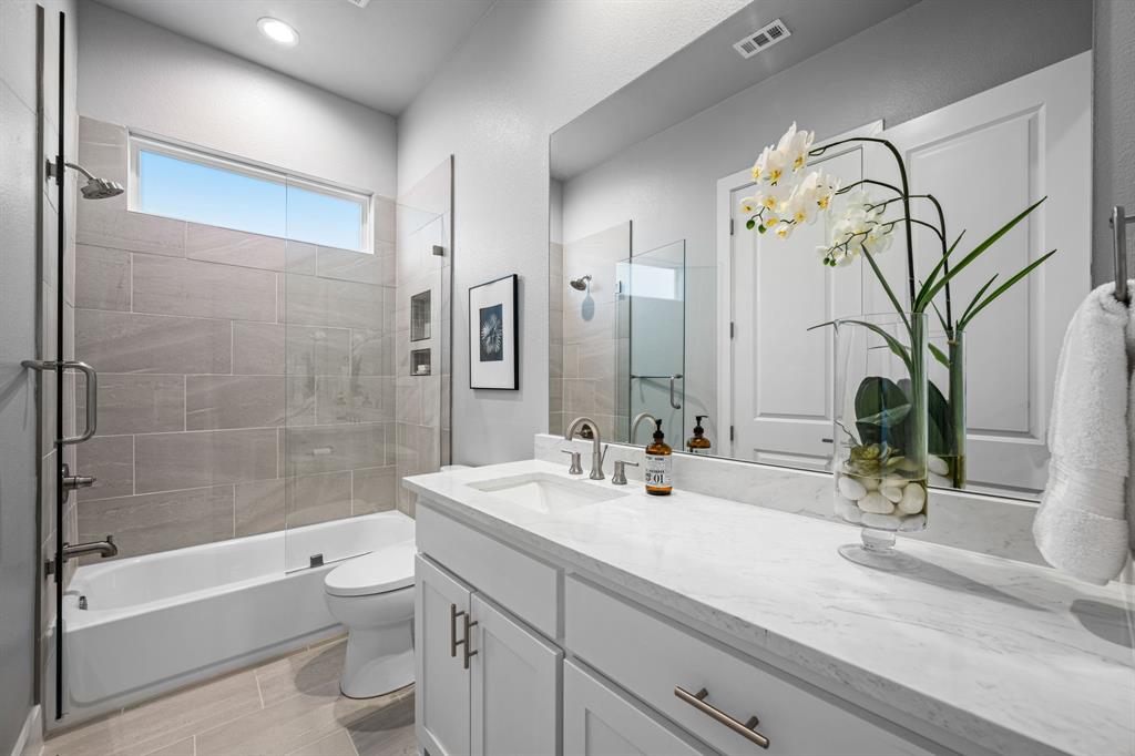 4138 Entrada Way Dallas, TX 75219 - Photo 25 of 40 a bathroom with a granite countertop sink a toilet and bathtub