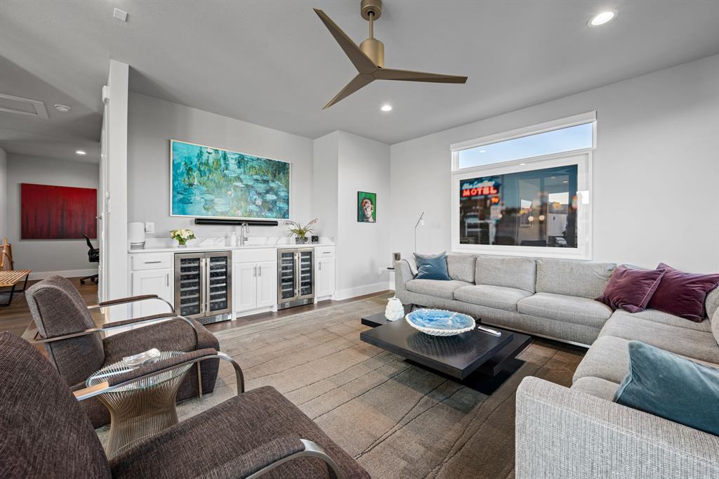 4138 Entrada Way Dallas, TX 75219 - Photo 32 of 40 a living room with furniture a flat screen tv and kitchen view