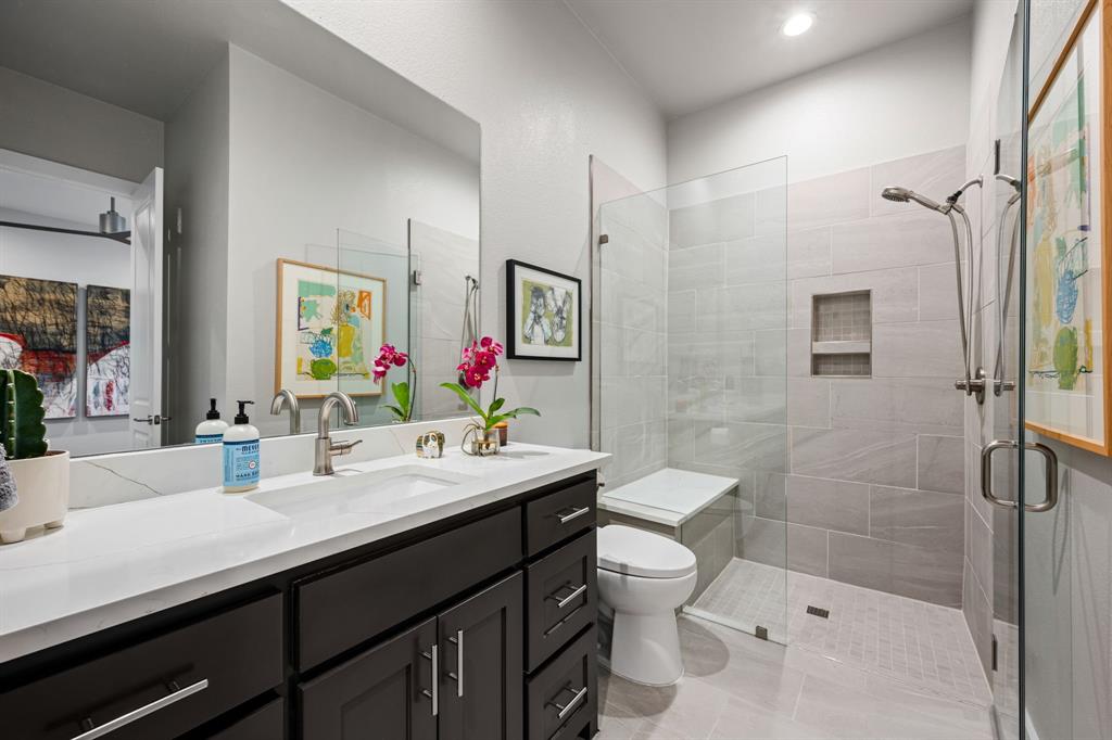 4138 Entrada Way Dallas, TX 75219 - Photo 39 of 40 a bathroom with a sink a toilet a shower and a mirror