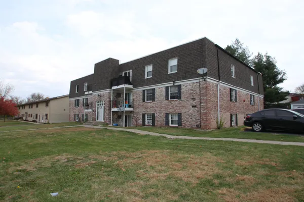a view of a big house with a yard and plants