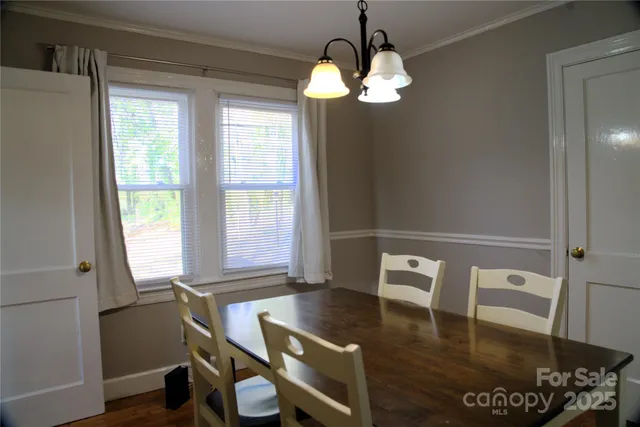 a view of a dining room with furniture a chandelier and wooden floor
