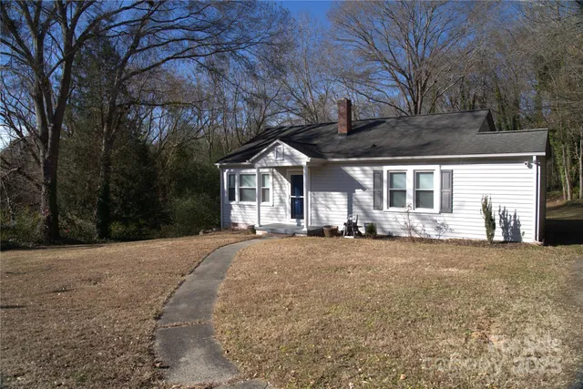 a front view of a house with yard and trees