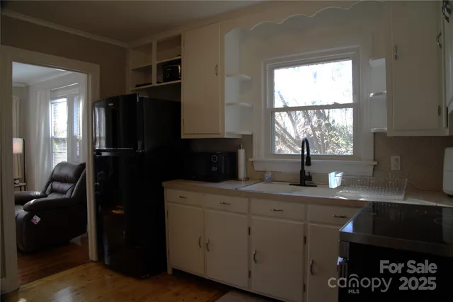 a kitchen with a sink a window and cabinets