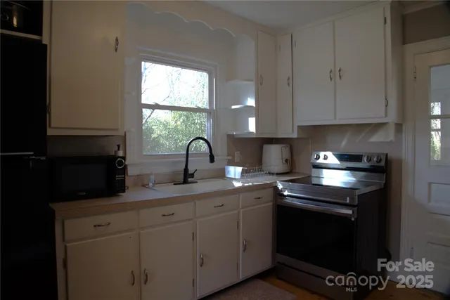 a kitchen with stainless steel appliances granite countertop a sink a stove and a microwave
