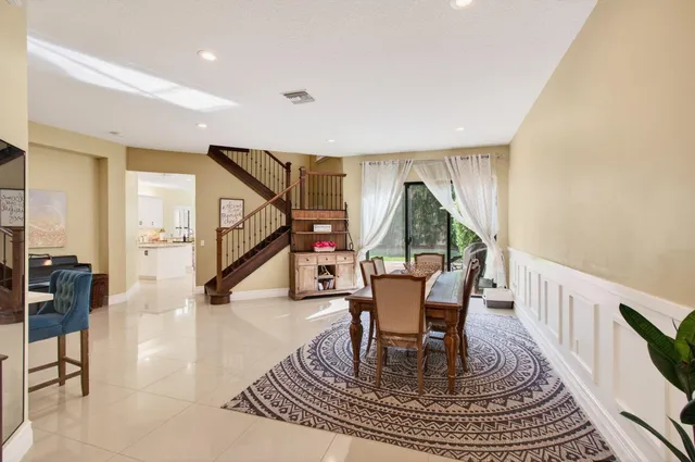 a view of swimming pool with table and chairs couches and palm trees