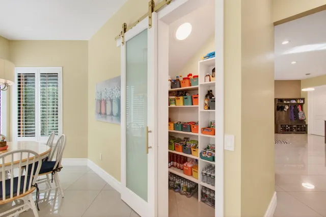 a view of a dining room with furniture a chandelier and large windows