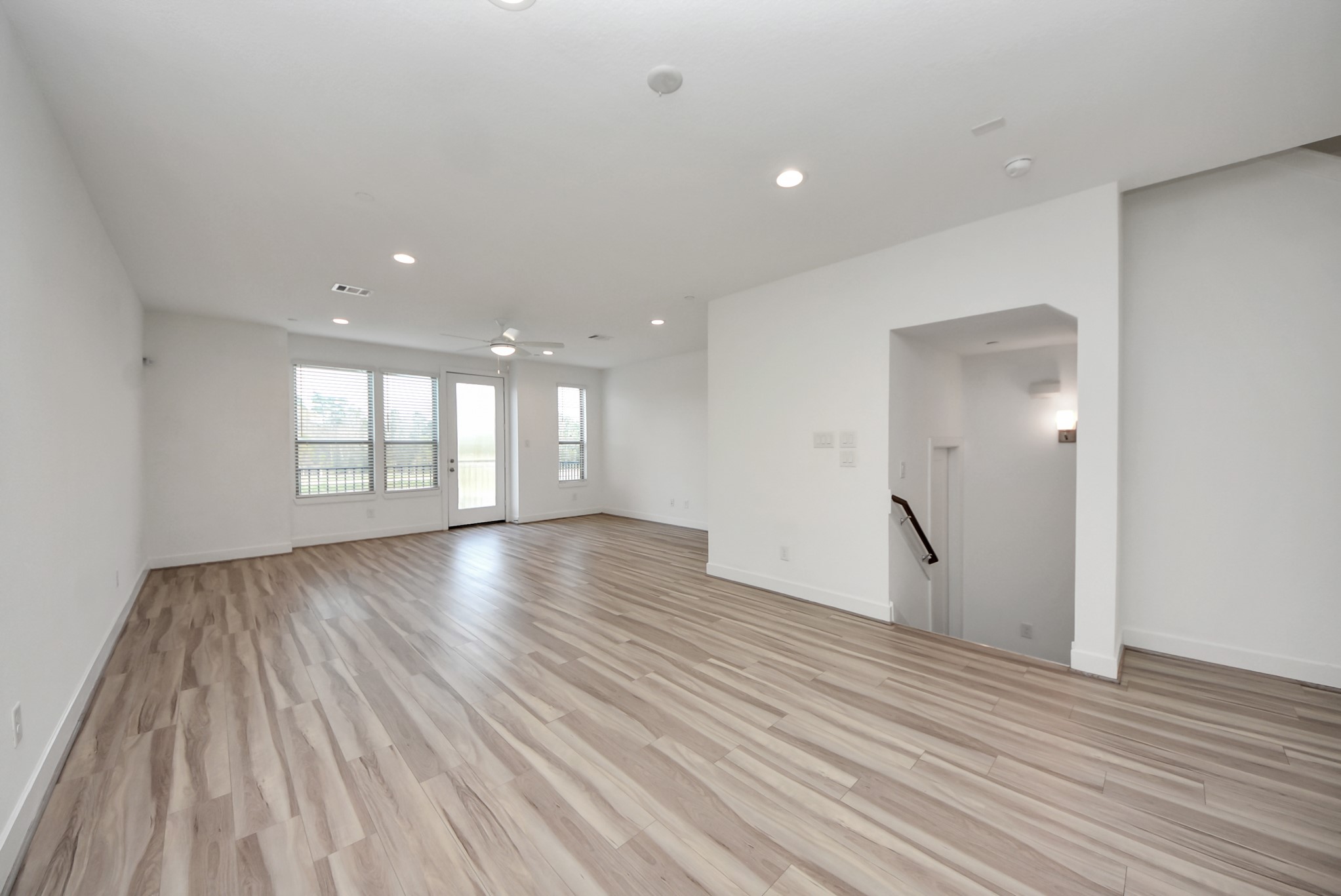 18716 Centro Main Street Conroe, TX 77385 - Photo 17 of 50 Spacious open-concept living area with wide-plank flooring, recessed lighting, and abundant natural light. Neutral finishes create a bright, flexible space ideal for entertaining or everyday living.