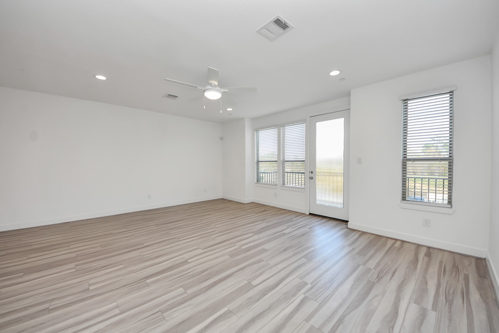 18716 Centro Main Street Conroe, TX 77385 - Photo 18 of 50 Bright and spacious living area with wide-plank flooring, recessed lighting, and large windows that fill the space with natural light.