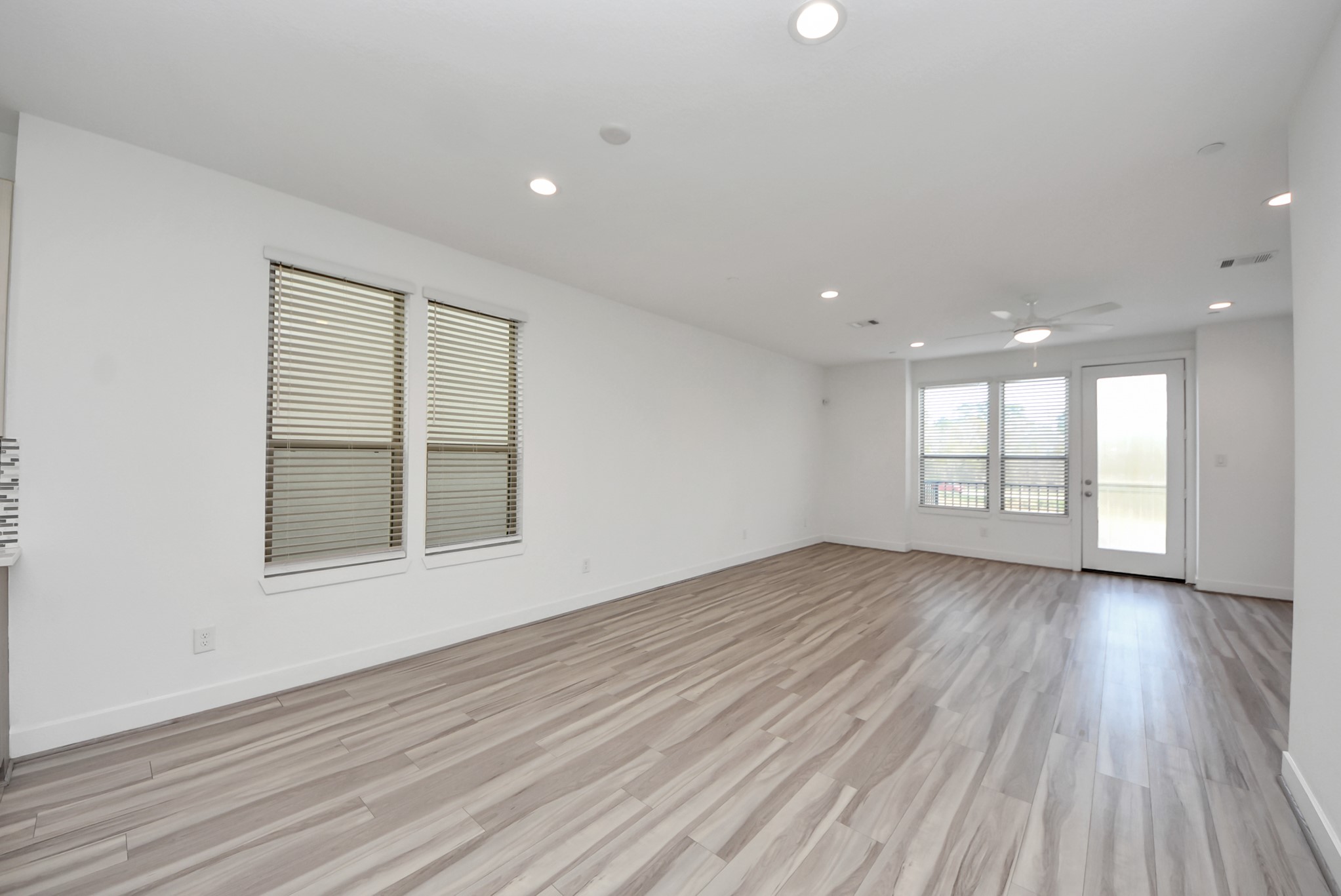 18716 Centro Main Street Conroe, TX 77385 - Photo 19 of 50 Expansive living area with modern finishes, large windows, and direct access to the balcony for indoor-outdoor flow.
