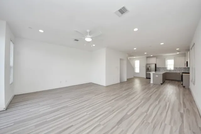a kitchen with stainless steel appliances kitchen island granite countertop a sink and a refrigerator
