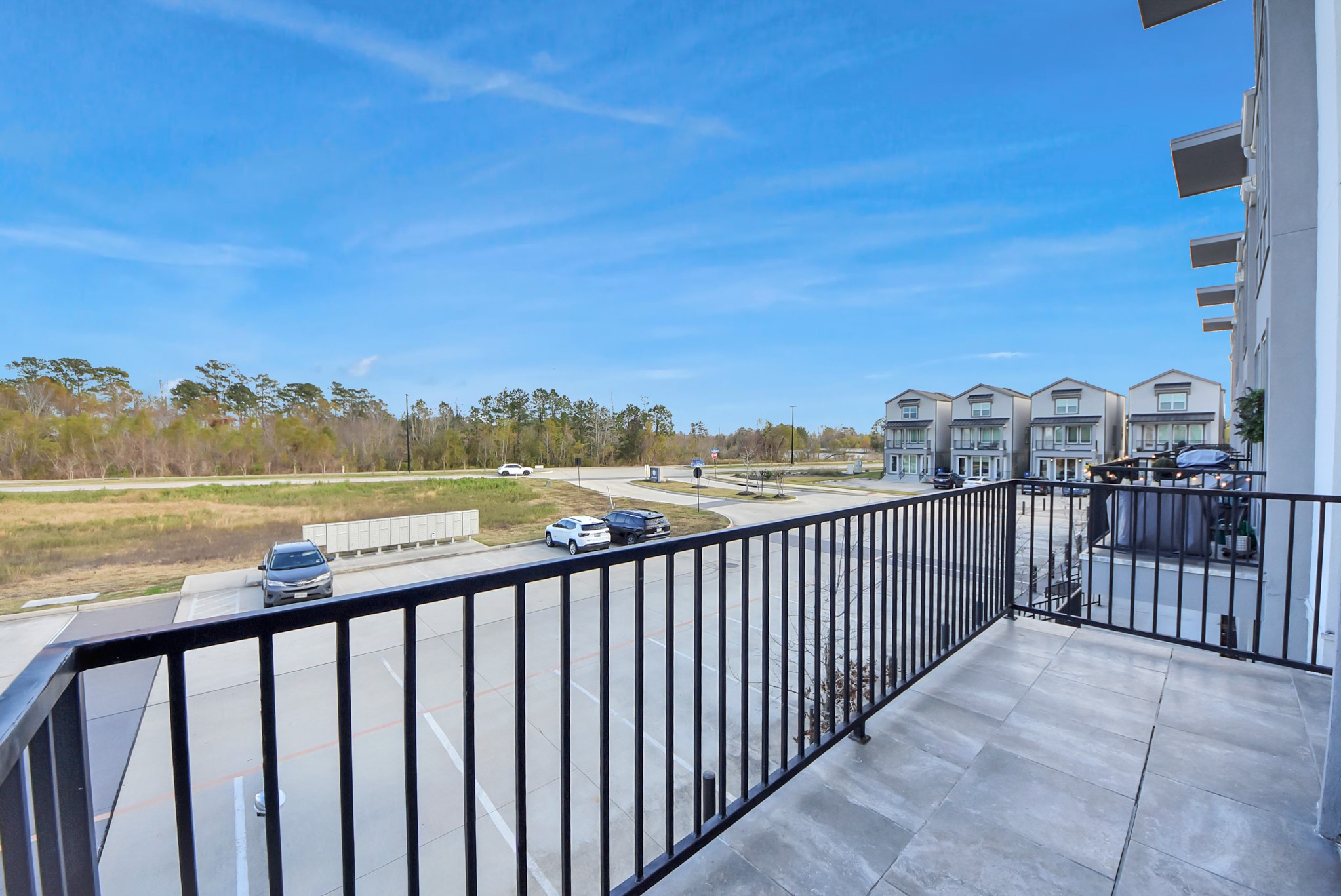 18716 Centro Main Street Conroe, TX 77385 - Photo 22 of 50 Private balcony overlooking the Centro community offering neighborhood views, and a peaceful outdoor space ideal for morning coffee or evening unwinding. Digitally Enhanced.