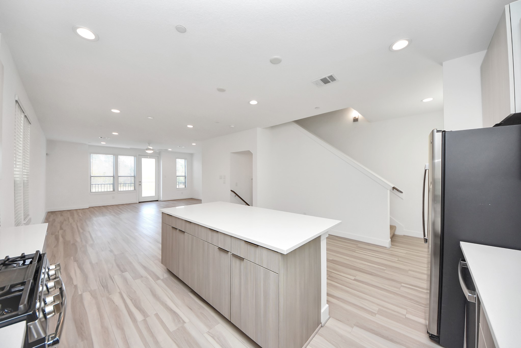 18716 Centro Main Street Conroe, TX 77385 - Photo 25 of 50 Modern kitchen featuring a large center island, quartz countertops, stainless steel appliances, and sleek contemporary cabinetry.