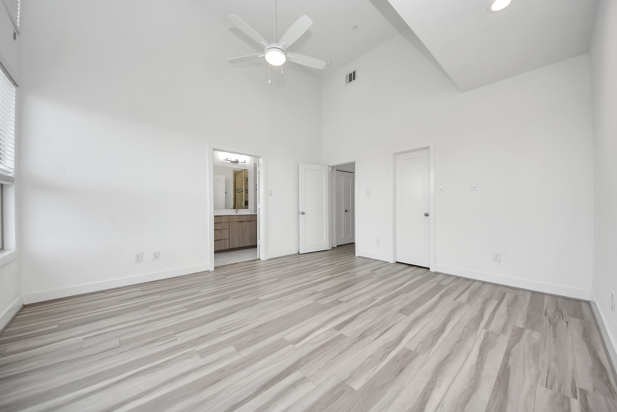 18716 Centro Main Street Conroe, TX 77385 - Photo 35 of 50 Spacious primary bedroom with elevated ceilings, ceiling fan, and direct access to the en-suite bathroom.