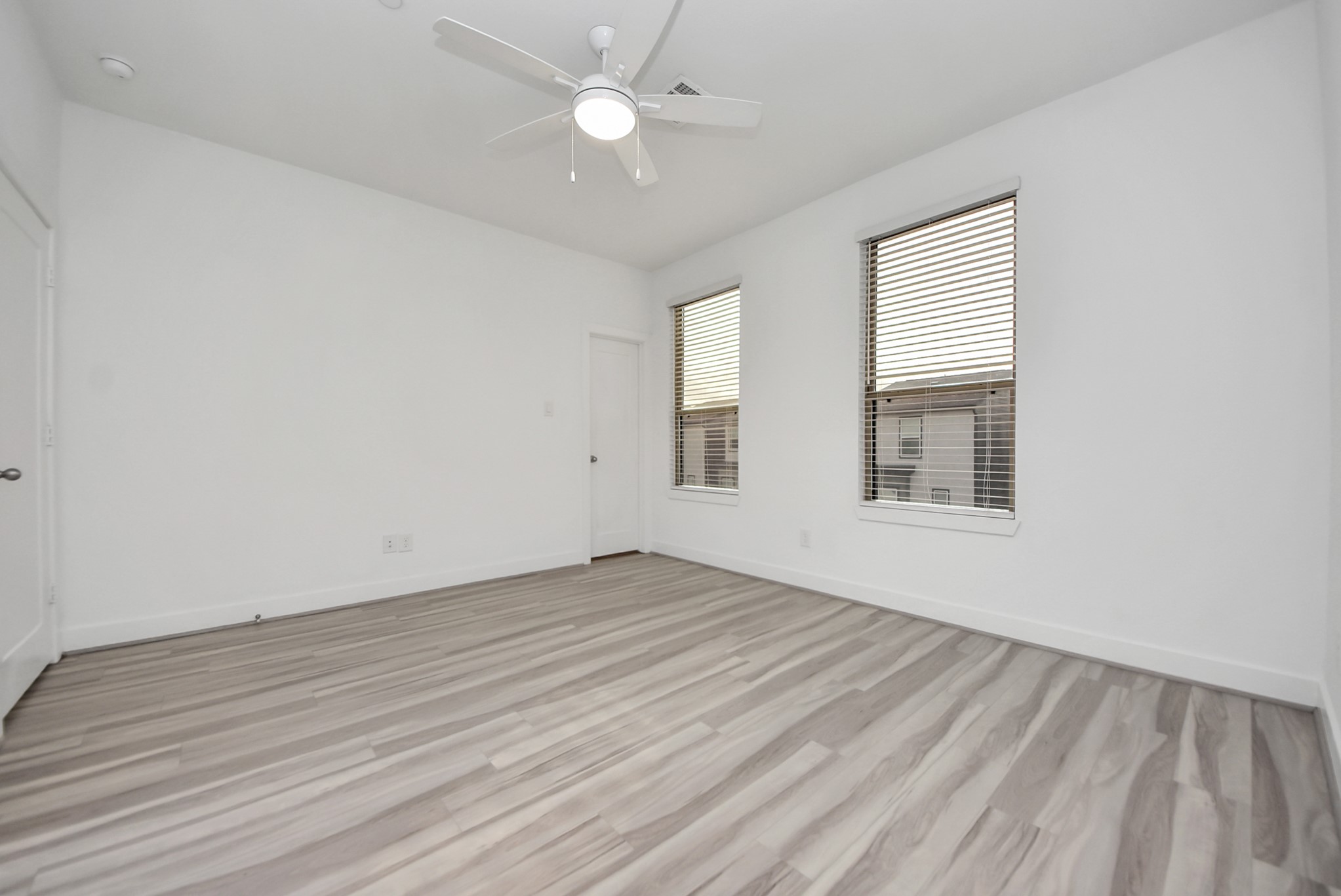 18716 Centro Main Street Conroe, TX 77385 - Photo 42 of 50 Secondary bedroom featuring wide-plank flooring, neutral finishes, ceiling fan, and two windows providing excellent natural light.
