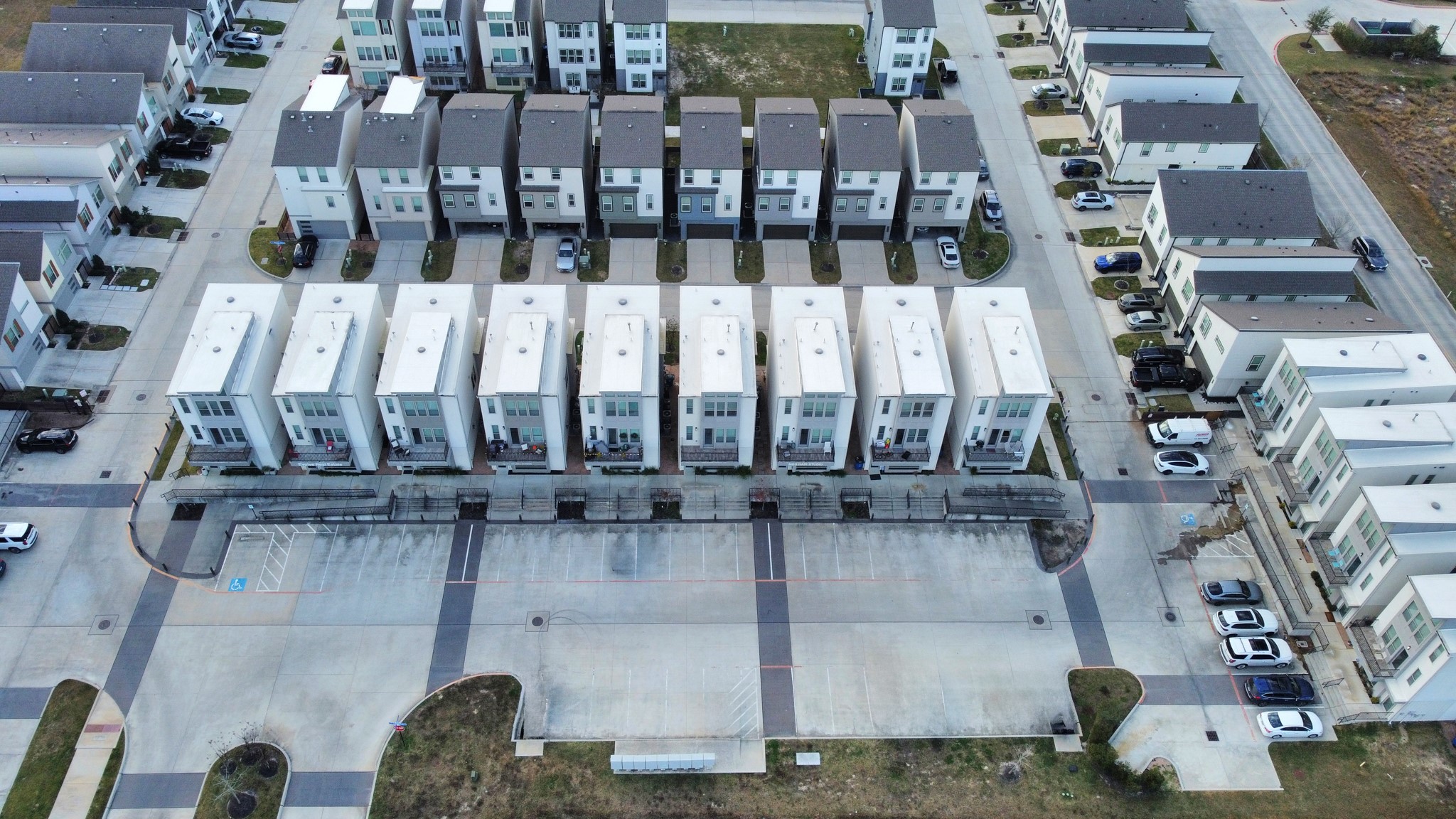 18716 Centro Main Street Conroe, TX 77385 - Photo 49 of 50 Aerial view showcasing a modern live/work community with clean architectural lines, private entrances, dedicated parking, and pedestrian-friendly walkways. Highlights the cohesive layout of the development and its mix of residential and ground-level commercial spaces.