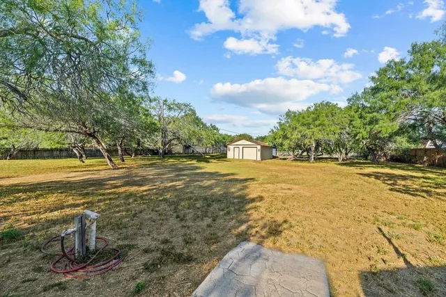 an aerial view of a house with a yard and lake view