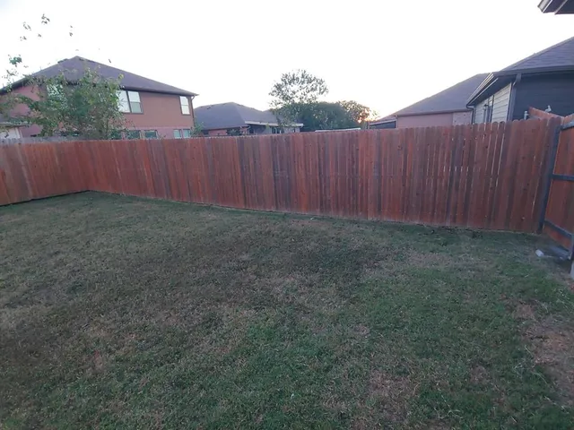 a view of backyard with wooden fence