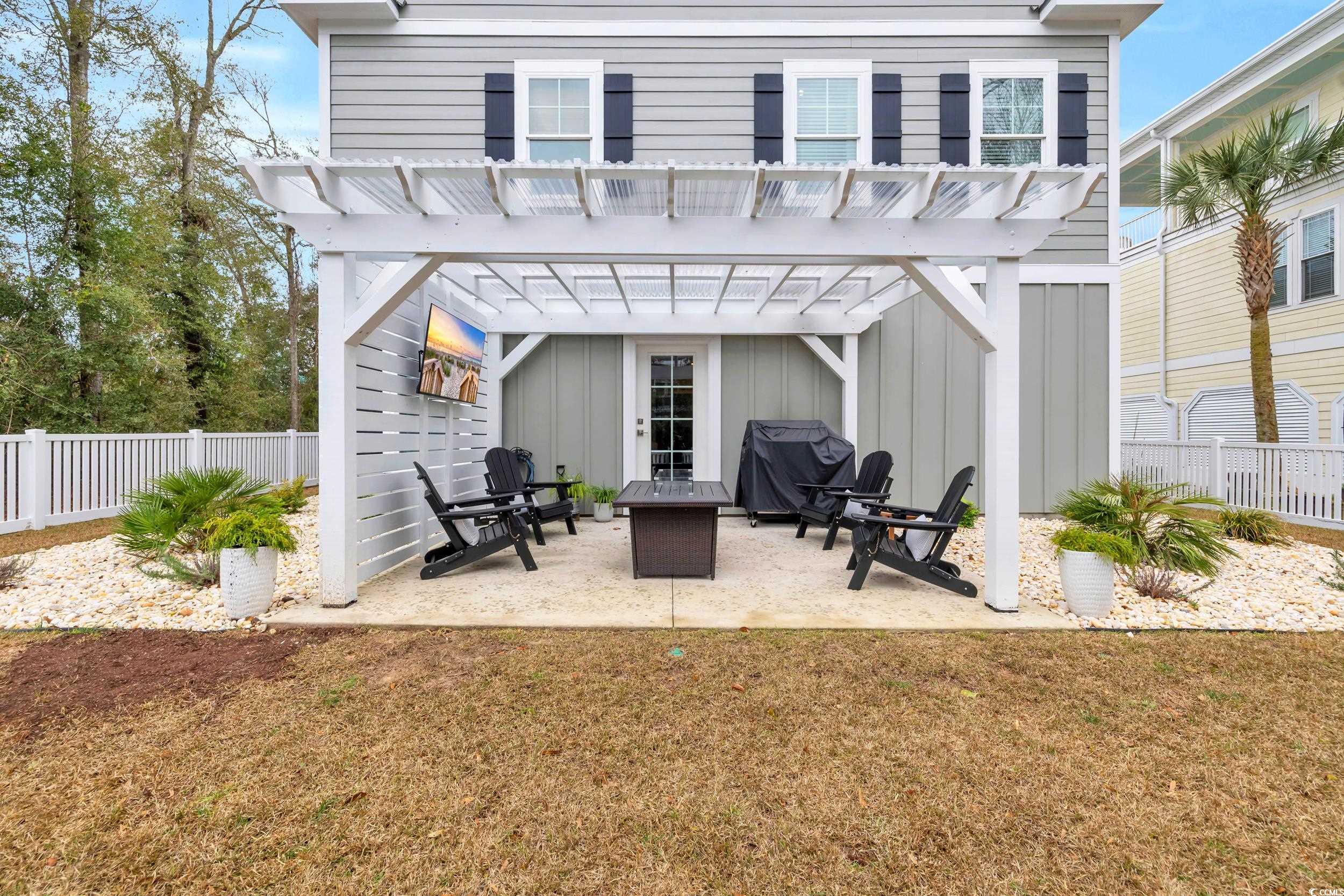 22 Trigger Fish Lane Murrells Inlet, SC 29576 - Photo 34 of 39 Back of property featuring a pergola, a patio area, and a lawn