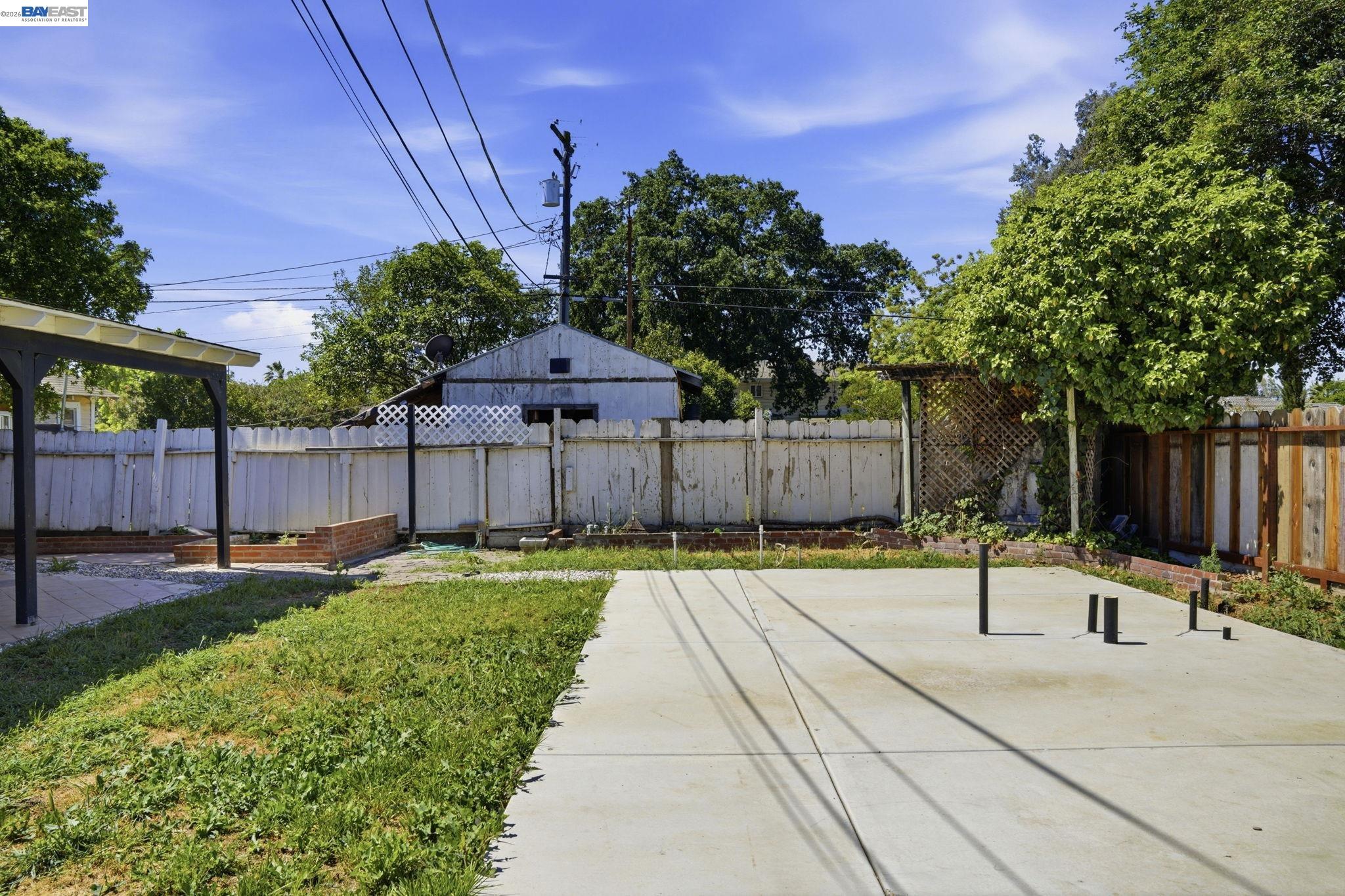 315 M Street Patterson, CA 95363 - Photo 16 of 17 a view of a backyard with wooden fence and a bench