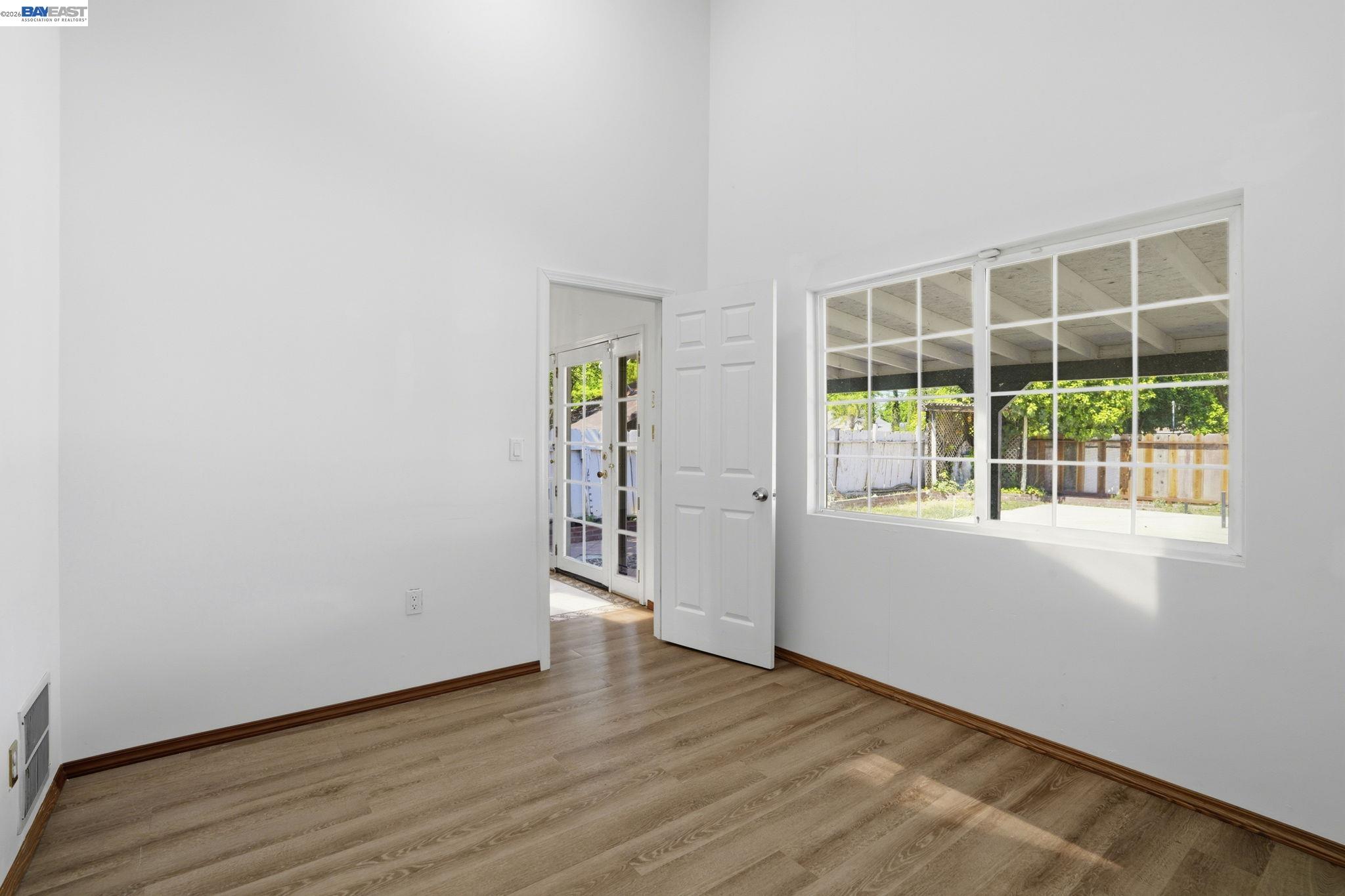 315 M Street Patterson, CA 95363 - Photo 10 of 17 an empty room with wooden floor and windows