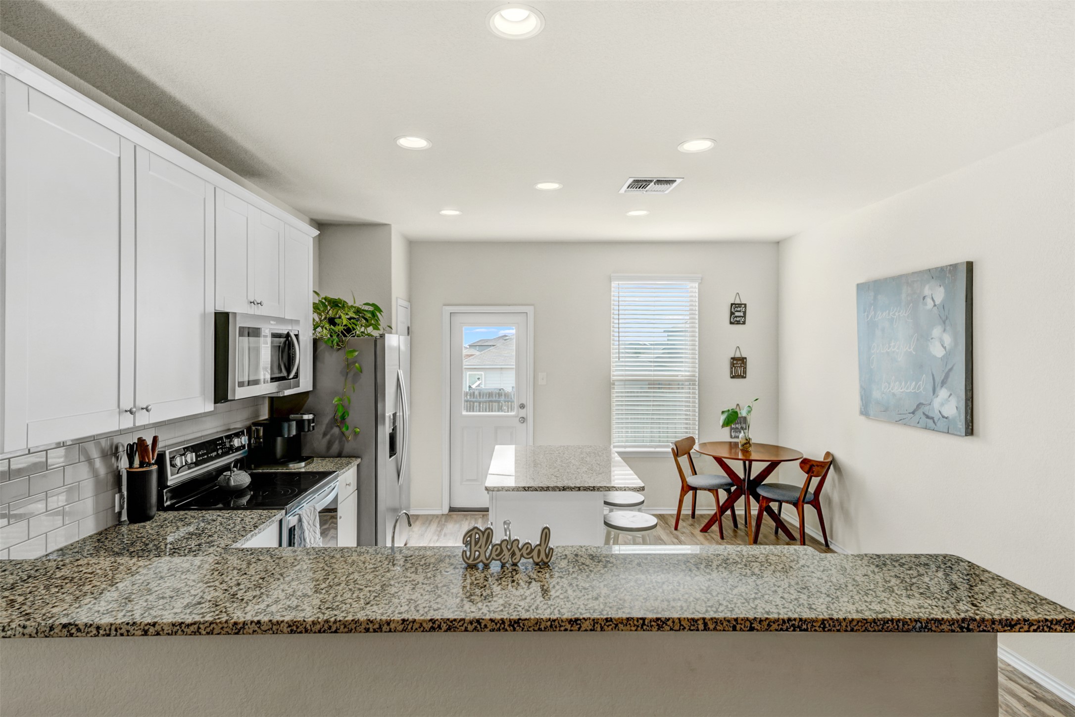 213 Ibis Falls Loop Jarrell, TX 76537 - Photo 9 of 37 A well-appointed kitchen showcasing elegant granite counters and modern recessed lighting.