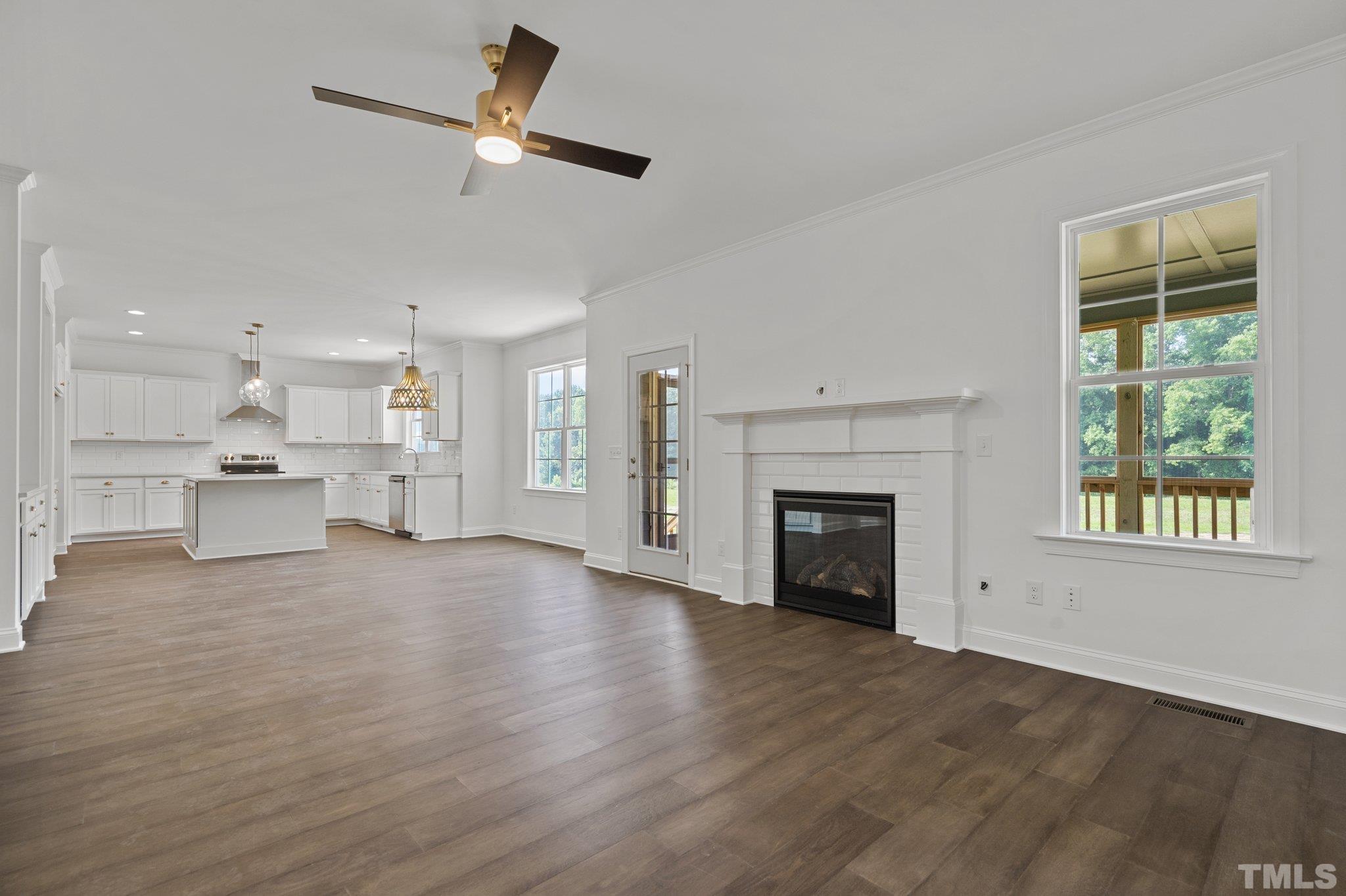 488 Pine Ridge Road Zebulon, NC 27597 - Photo 11 of 47 a view of an empty room with a fireplace and a window